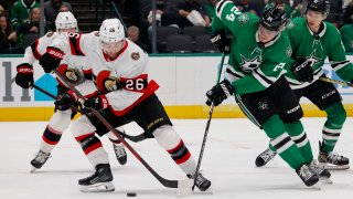 Ottawa Senators defenseman Erik Brannstrom (26) and Dallas Stars center Roope Hintz (24) battle for the puck during the first period of an NHL hockey game in Dallas, Friday, Dec. 15, 2023.