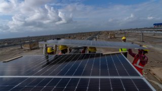 Workers install solar panels at the under-construction Adani Green Energy Limited's Renewable Energy Park in the salt desert of Karim Shahi village, near Khavda, Bhuj district near the India-Pakistan border in the western state of Gujarat, India, Thursday, Sept. 21, 2023. Led by new solar power, the world added renewable energy at breakneck speed in 2023, in an effort to turn away from fossil fuels to stave off severe Earth warming and its effects.