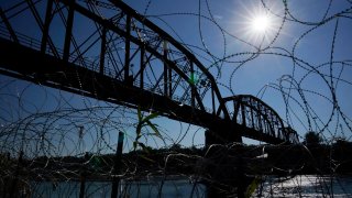 The Union Pacific International Railroad Bridge is seen behind concertina wire, Sept. 22, 2023, in Eagle Pass, Texas. The federal government on Friday, Dec. 22, reopened railroad crossings in two Texas border towns, including Eagle Pass, days after the shuttering of rail operations there disrupted trade and caused outrage.