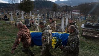 Ukrainian servicemen carry the coffin of their comrade Vasyl Boichuk who was killed in Mykolayiv in March 2022, during his funeral ceremony at the cemetery in Iltsi village, Ukraine, Tuesday, Dec. 26, 2023.