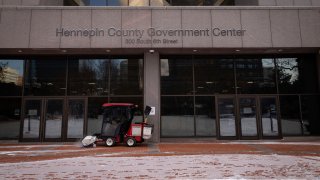 FILE - Snow is removed from the entrance of the Hennepin County Government Center in Minneapolis