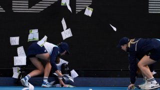 Ball kids pickup "free Palestine" leaflets thrown onto Margaret Court Arena.