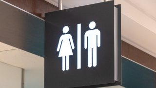 File. 2019/02/02: Public washroom or bathroom sign hanging from the ceiling of Pearson International Airport.