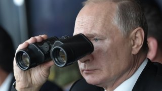 Russian President Vladimir Putin watches with binoculars the Tsentr-2019 military exercise at the Donguz range near Orenburg city on September 20, 2019.