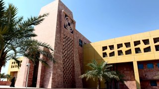 FILE – A Qatari student walks to a building in the Texas A&M University campus at Education City, on Tuesday, Oct. 18, 2011, in Doha, Qatar. Texas A&M University will close its 20-year-old Qatar campus by 2028, with board members noting “heightened instability” in the Middle East as a major reason to reconsider its presence in the country.