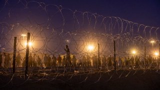 FILE - People wait at the U.S.-Mexico border fence in El Paso, Texas, in May 2023.