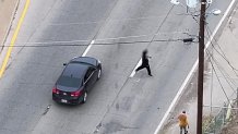 A man runs across Ledbetter Drive, avoiding an oncoming car.