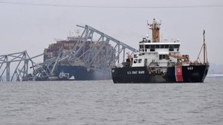 The US Coast Guard Cutter Frank Drew (R) patrols near the collapsed Francis Scott Key Bridge after it was struck by the container ship Dali in Baltimore, Maryland, on March 27, 2024. 