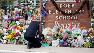 FILE – Reggie Daniels pays his respects at a memorial at Robb Elementary School, June 9, 2022, in Uvalde, Texas.