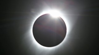 JACKSON, WY – AUGUST 21: The sun is partially eclipsed in the first phase of a total eclipse in Grand Teton National Park on August 21, 2017 outside Jackson, Wyoming. Thousands of people have flocked to the Jackson and Teton National Park area for the 2017 solar eclipse which will be one of the areas that will experience a 100% eclipse on Monday August 21, 2017. (Photo by George Frey/Getty Images)