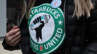 A Starbucks worker wears a t-shirt and button promoting unionization on April 7, 2022, in Chicago.