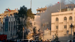 Emergency services work at a destroyed building hit by an air strike in Damascus, Syria, Monday, April 1, 2024.