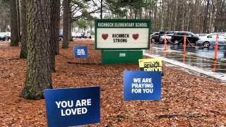FILE - Signs stand outside Richneck Elementary School in Newport News, Va., Jan. 25, 2023.