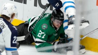 Dallas Stars left wing Mason Marchment (27) is slammed against the boards by Winnipeg Jets’ Logan Stanley, top, as Jets’ Mason Appleton (22) looks on in the second period of an NHL hockey game in Dallas, Thursday, April 11, 2024.