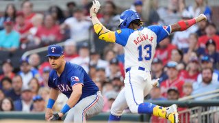Atlanta Braves’ Ronald Acuña Jr. (13) is safe at first base with a single as Texas Rangers first baseman Nathaniel Lowe waits for the late throw in the first inning of a baseball game Saturday, April 20, 2024, in Atlanta. (AP Photo/John Bazemore)