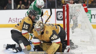 Vegas Golden Knights defenseman Noah Hanifin (15) collides into Dallas Stars center Wyatt Johnston (53) while Vegas Golden Knights goaltender Logan Thompson (36) makes a save during the third period in Game 3 of an NHL hockey Stanley Cup first-round playoff series Saturday, April 27, 2024, in Las Vegas.