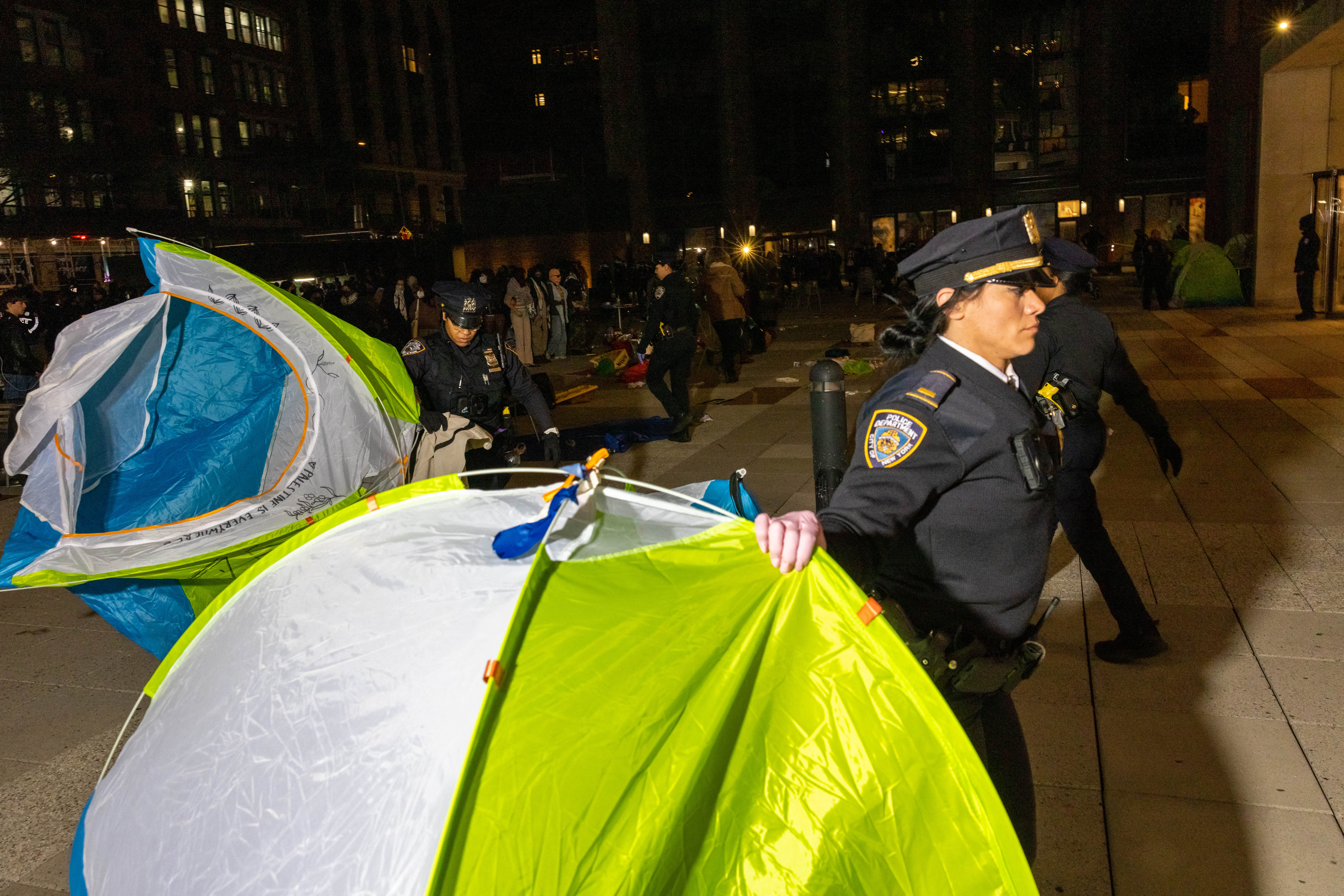 NYPD officers clear away tents from an encampment set up by pro-Palestinian students and protesters on the NYU campus on Monday, April 22, 2024.