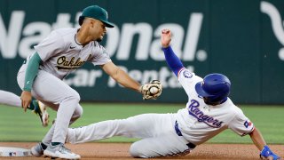 Texas Rangers’ Marcus Semien, right, steals second base as Oakland Athletics shortstop Darell Hernaiz makes the late tag during the first inning of a baseball game Thursday, April 11, 2024, in Arlington, Texas. (AP Photo/Michael Ainsworth)