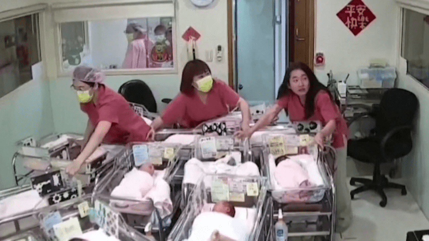 Nurses hold baby bassinets in maternity ward nursery during earthquake