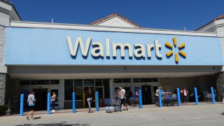 People walk near the entrance to a Walmart Supercenter in Hallandale Beach, Florida, on Feb. 20, 2024.