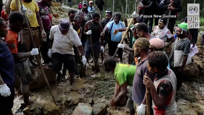 Rescuers look for people buried in a landslide