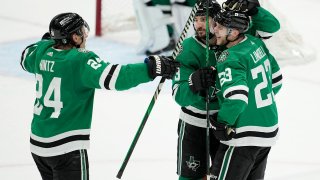 Dallas Stars’ Roope Hintz (24), Chris Tanev (3) and Esa Lindell (23) celebrate Lindell’s empty-net goal against the Colorado Avalanche late in the third period in Game 2 of an NHL hockey Stanley Cup second-round playoff series in Dallas, Thursday, May 9, 2024. (AP Photo/Tony Gutierrez)