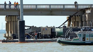 Workers survey the site where a barge crashed into the Pelican Island Bridge, Wednesday, May 15, 2024, in Galveston, Texas.