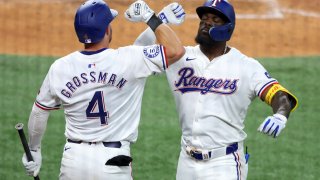 Texas Rangers Robbie Grossman (4) celebrates the home run by Adolis Garcia, right, against the Los Angeles Angels in the sixth inning of a baseball game Saturday, May 18, 2024, in Arlington, Texas. (AP Photo/Richard W. Rodriguez)