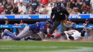 Minnesota Twins’ Carlos Santana, right, is tagged out by Texas Rangers catcher Jonah Heim, left, to end the bottom of the seventh inning of a baseball game Saturday, May 25, 2024, in Minneapolis. (AP Photo/Abbie Parr)