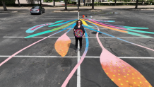 Artist with completed mural Meow Wolf Grapevine