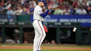 Texas Rangers’ Nathan Eovaldi tosses the rosin bag as he walks behind the mound before throwing to Washington Nationals’ Luis Garcia Jr. in the sixth inning of a baseball game in Arlington, Texas, Thursday, May 2, 2024. Eovaldi left the game with an unknown injury in the inning. (AP Photo/Tony Gutierrez)