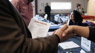 Attendees shake hands at a Veteran Employment and Resource Fair in Long Beach, California, US, on Tuesday, Jan. 9, 2024. The Department of Labor is scheduled to release initial jobless claims figures on January 11. 