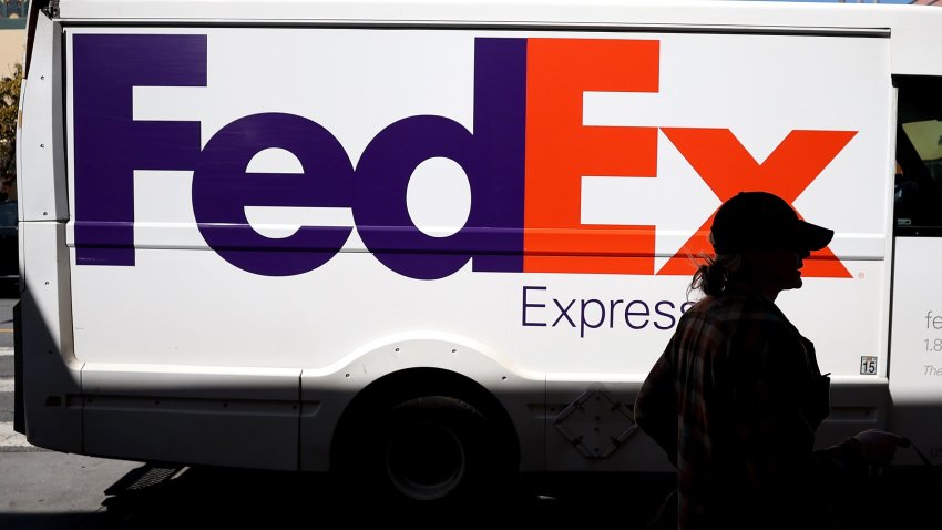 A pedestrian walks by a parked FedEx delivery truck on March 21, 2024 in San Francisco, California.