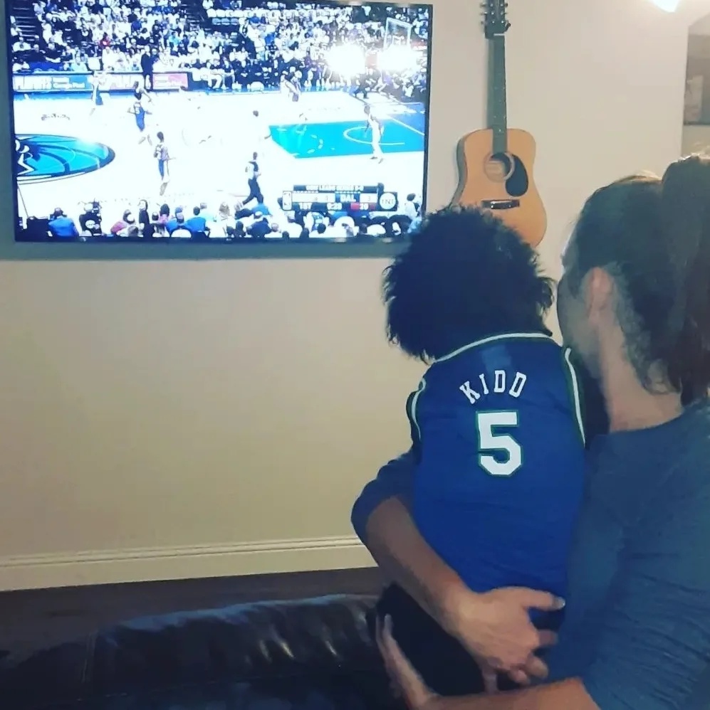 Marley wearing his Jason Kidd retro Mavs jersey, and watching the game with Mom.