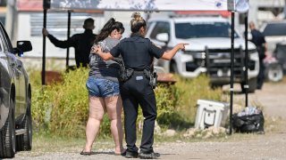 A Bexar County Sheriff Deputy, right, talks to a handcuffed woman during a law enforcement sting, Thursday, June 6, 2024, in San Antonio.