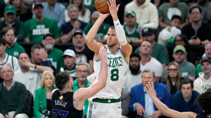 Boston Celtics center Kristaps Porzingis (8) shoots over Dallas Mavericks guard Luka Doncic (77) during the second half of Game 1 of basketball’s NBA Finals on Thursday, June 6, 2024, in Boston.