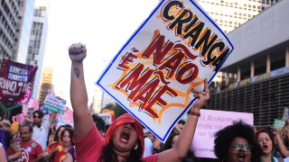 An abortion rights activist holds a sign with a message that reads in Portuguese, “A child is not a mother” during a march against an anti-abortion congressional bill, along Paulista Avenue in Sao Paulo, Saturday, June 15, 2024.