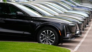 FILE - Vehicles sit in a row outside a dealership, June 2, 2024, in Lone Tree, Colo.