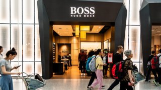 Pedestrians walk past a German luxury fashion house Hugo Boss store in Shenzhen Bao’an International Airport.