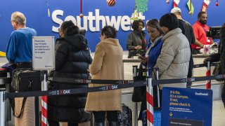 Travelers wait to check in at the Southwest Airlines counter at Oakland International Airport in Oakland, California, Dec. 27, 2022.