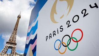 The Paris 2024 logo representing the Olympic Games is displayed near the Eiffel Tower in Paris on April 21, 2024, in anticipation of the 2024 Paris Olympic Games and Paralympic Games.