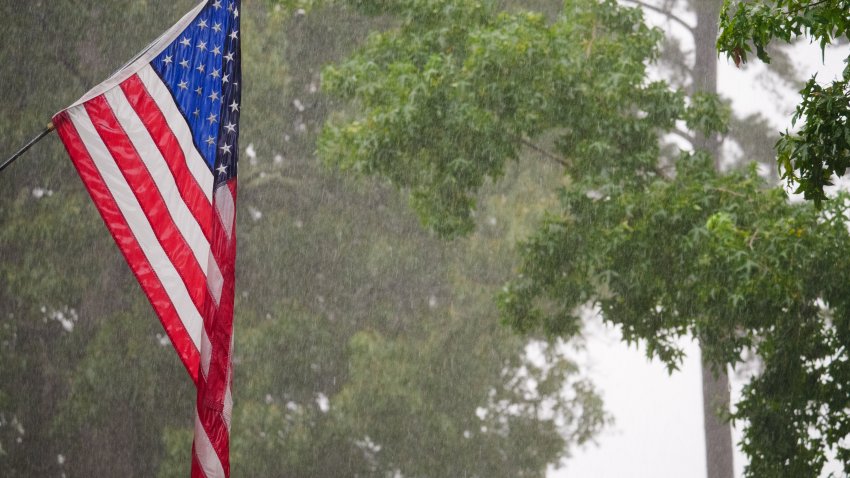 An American flag hangs in the rain.