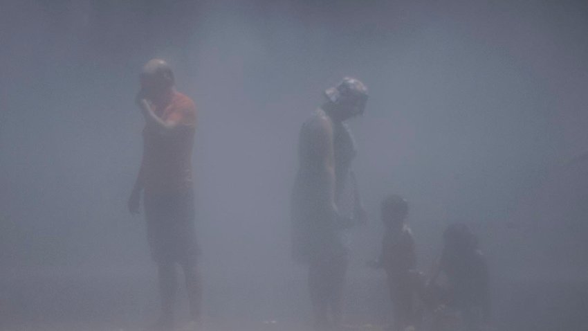 People cool off at a fountain in the Madrid Rio park amid heatwave conditions in Madrid on July 23, 2024.