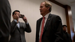 Texas Attorney General Ken Paxton enters the 185th Criminal District court at the Harris County Criminal Justice Center for a pretrial hearing in his securities fraud case on March 26, 2024, in Houston.