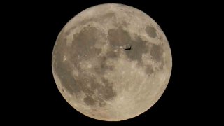 Plane passes by the moon