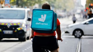 A delivery worker with a backpack of Deliveroo rides a bike in Nice, France, October 25, 2022.