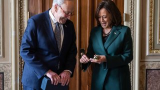 US Senate Majority Leader Chuck Schumer presents US Vice President Kamala Harris with a “golden gavel” after she cast her 32nd tie-breaking vote in the Senate, the most ever cast by a Vice President, at the US Capitol in Washington, DC, December 5, 2023.