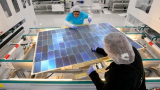 Monica Muñoz, top, and Denise Denning place black encapsulation material on solar panels at Elin Energys solar panel manufacturing facility on Thursday, April 25, 2024 in Brookshire. 