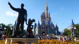 A statue of Walt Disney and Mickey Mouse stands in a garden in front of Cinderella’s Castle at the Magic Kingdom Park at Walt Disney World on May 31, 2024, in Orlando, Florida. 