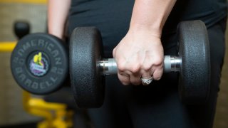 Shauntil Cox lifts weights with the help of her trainer, Deano Troost, at a Planet Fitness in New Caney, Texas, on Sept. 19, 2023.